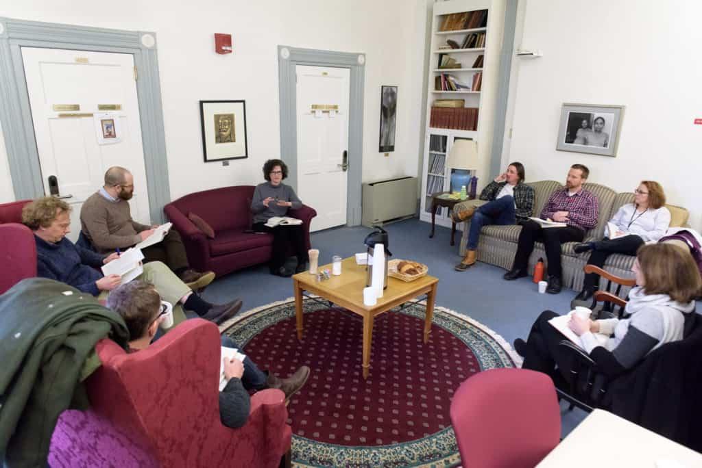 faculty sitting in a room discussing a book